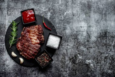 Siyah arka planda baharatlı ızgara biftek.