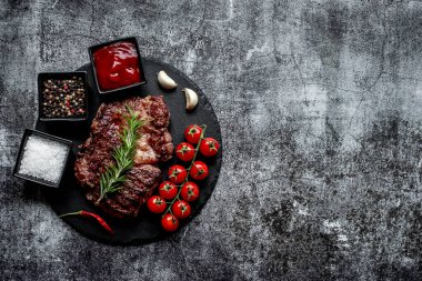 Siyah arka planda baharatlı ızgara biftek.