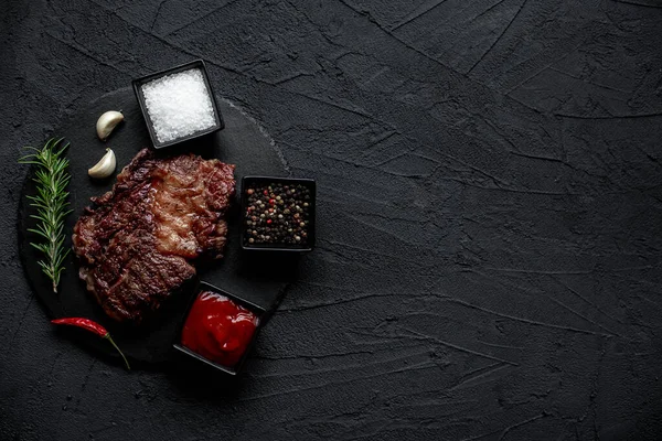 stock image grilled beef steak with spices on black background