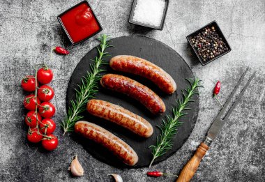 Alman ızgara sosisi, biberiye ve arkaplanda baharatlar.