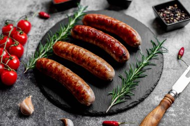 Alman ızgara sosisi, biberiye ve arkaplanda baharatlar.