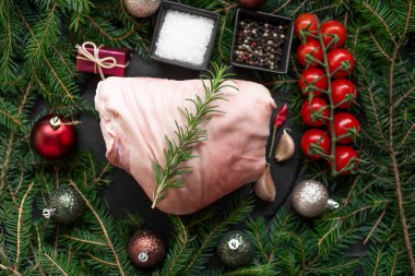 Baharatlı çiğ domuz eti ve siyah yüzeyde noel dekoru. 