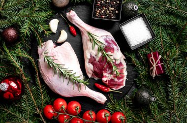 Baharatlı çiğ ördek bacakları ve arka planda Noel süslemeleri.