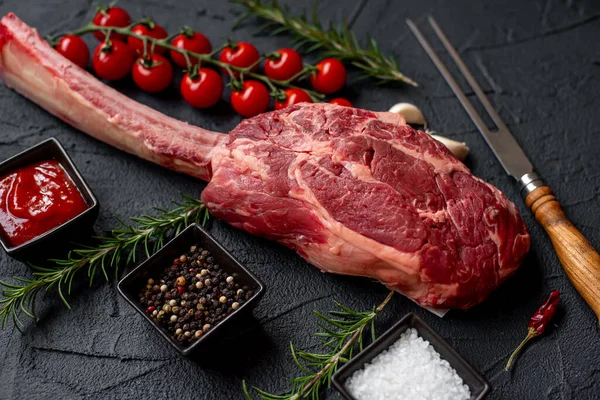 Roh Tomahawk Steak Und Gewürze Auf Schwarzem Stein Hintergrund — Stockfoto