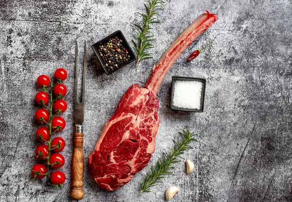 Roh Tomahawk Steak Und Gewürze Auf Grauem Stein Hintergrund — Stockfoto