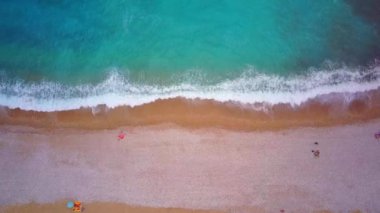 Hava manzaralı dalgalar beyaz kumsalda kırılır, kara denizle buluşur..
