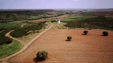 İspanya, Castilla la la Mancha 'da gün batımında tepede yel değirmeni. Havadan bak, kuş uçuşu.