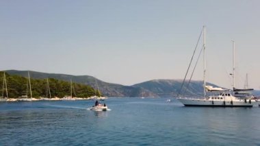 Uzaktaki Kefalonya Adası 'na turistlerle birlikte Yunan sularına giden turist botu, limana yanaşmış büyük bir limana sahip olan Azure sularının ve ada manzarasının manzarasını görebilir.. 