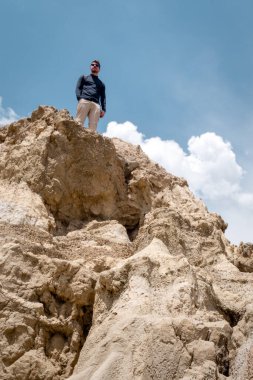 Valle de la Luna (Ay Vadisi), La Paz, Bolivya 'daki uçurumun tepesinde duran genç bir adam. Dikey fotoğrafçılık