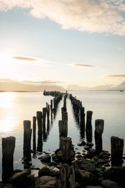 Gün batımında tahta iskelenin eski kalıntıları. Puerto Natales, Patagonya, Şili