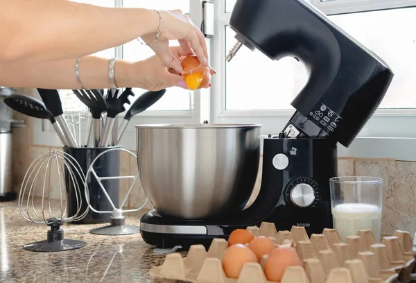 Working With A Handheld Electric Mixer In The Kitchen Stock Photo
