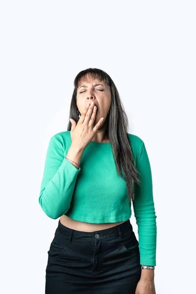 Hispanic Brunette Woman Yawning Covering Her Mouth Hand White Background lizenzfreie Stockbilder