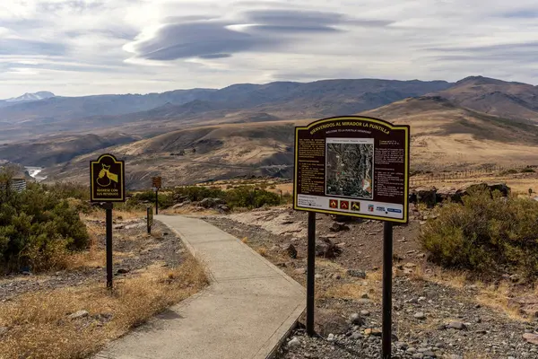 Mirador La Puntilla 'nın uzaylı figürlü manzarası. Engebeli bir manzara, bulutlu gökyüzünün altındaki dağlar. 9 Nisan 2025. Neuquen, Arjantin