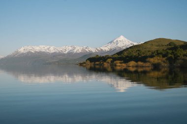Güneşli bir sabahta Huechulafquen Gölü 'nün yanındaki Majestic Volcano Lanin. Patagonya, Neuquen, Arjantin