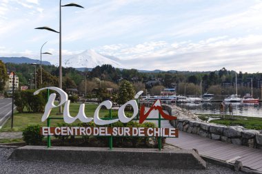 Pucon turistik tabelası. Limanın karlı volkanik zirvesi destansı manzaralı. Araucania, Şili