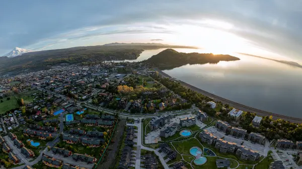 Güneş batarken Villarrica Gölü ve volkan manzaralı Pucon şehrinin hava panoramik manzarası.