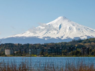 Villarrica volkanı Villarrica Gölü 'nün üzerinde güzel apartman binalarıyla görüldü. Patagonya, Şili