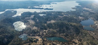 Villa Pehuenia ve Moquehue 'nun havadan panoramik manzarası. Yuvarlanan tepeler ve seyrek bitki örtüsü arasında pek çok göl var. Neuquen, Patagonya, Arjantin