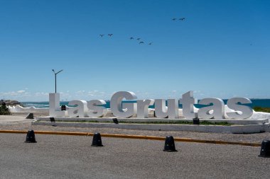 Las Grutas okyanus manzaralı hoş geldin tabelası mavi gökyüzü arkaplanı altında. Rio Zenci Bölgesi, Arjantin
