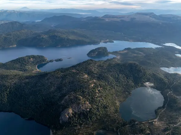 Alumine Gölü 'nün havadan görünüşü ve ormanlık tepeler ve Andean sıradağlarıyla çevrili küçük 4 lagün. Villa Pehuenia, Neuquen, Arjantin