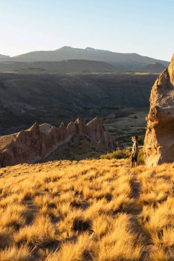 Los Bolillos 'ta sonbahar manzarasının tadını çıkaran adam Arjantin' in kuzeyindeki Neuquen bölgesindeki kaya oluşumlarını aşındırdı.