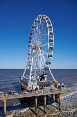Scheveningen, Hollanda - 3 Nisan 2023: Scheveningen, Hollanda sahilinde dönme dolaptaki insanlar