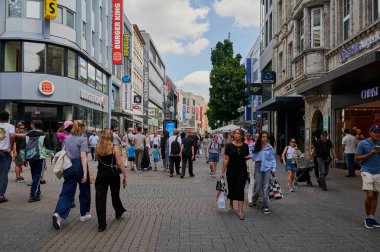 Köln, Almanya - 05 Ağustos 2024: Kolognes şehir merkezinde büyük bir alışveriş caddesi olan Schildergasse 'de insanlar alışveriş yapıyor