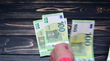 Koyu ahşap yüzeyde 100 Euro 'luk banknotları sayma videosu