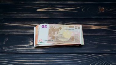 Tahta arka planda farklı banknotlar ile para demetleri el yerleştirin, video