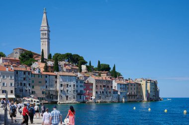 Rovinj, Istria, Hırvatistan - 24 Mayıs 2024: Istria 'nın batı kıyısındaki sevimli bir liman kasabası olan Rovinj köyünde turistler ve Hırvatistan' ın en güzel yerlerinden biri