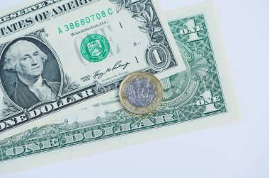 Bir sterlin bir dolarlık banknotun üzerinde duruyor, para ve değer kavramını vurguluyor..