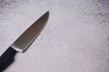 Mutfak bıçağı desenli bir yüzeye yerleştirilmiş keskin bıçak ve sapını, kopyalanmış uzayı gösteriyor.