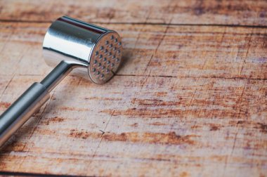 Köy ahşap bir yüzeye metal et yumuşatıcısı yerleştirilir. Kalıplaşmış kafası görünür..