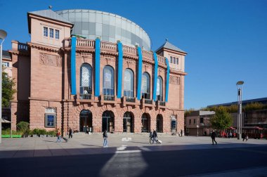 Mainz, Almanya - 25 Ekim 2024: İnsanlar Mainz eyalet tiyatrosunun önünde yürüyüp açık ve aydınlık bir günün tadını çıkarıyorlar.