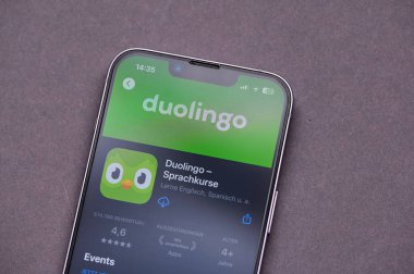Mainz, Almanya - 09 Haziran 2025: Bir akıllı telefon, popüler dil öğrenme uygulaması Duolingo 'nun logosunu ekranda canlı renkler ve net simgelerle rahat bir ortamda gösterir.