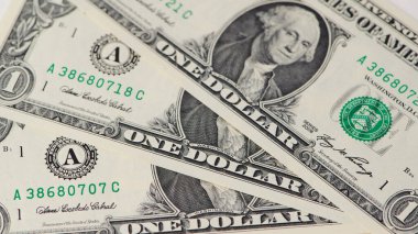 Üç tane bir dolarlık banknot düz bir yüzeye düzgün bir şekilde yerleştirilmiş ve net detaylar ortada..