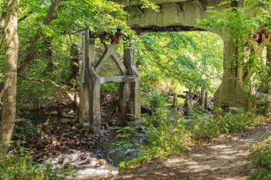 Otwock 'taki nehrin üzerinde eski bir viyadük. Nehir eski köprünün altından akıyor. Suyla manzara. Avrupa, Polonya, Mazovia.