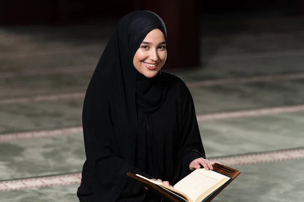 Beautiful Muslim Woman in Hijab Dress Sitting in Mosque and Praying With Quran
