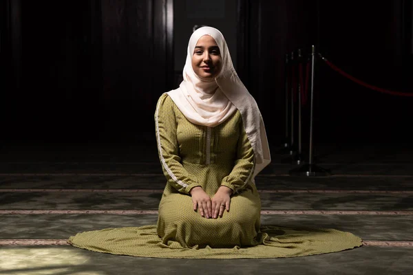 美しいイスラム教徒の女性でヒジャーブのドレスモスクに座って祈ります — ストック写真