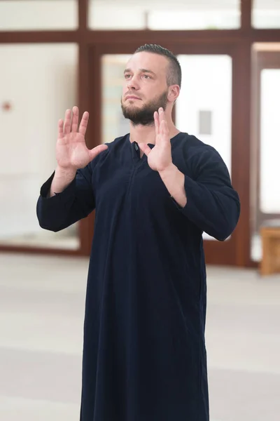 伝統的なキャップ ディスダーシャを身に着けている間神に伝統的な祈りを作る若いイスラム教徒の男性 — ストック写真