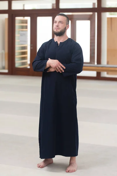 伝統的な帽子をかぶっている間に神に伝統的な祈りをする若いイスラム教徒の男 Disshada — ストック写真