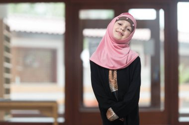Geleneksel başörtüsü takmış, Allah 'a dua eden genç bir müslüman kızın portresi