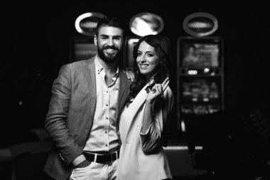 Kumarhanede oynayan güzel ve iyi giyimli bir çiftin portresi.