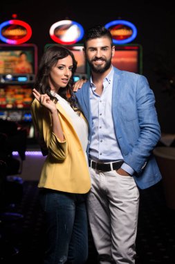 Kumarhanede oynayan güzel ve iyi giyimli bir çiftin portresi.