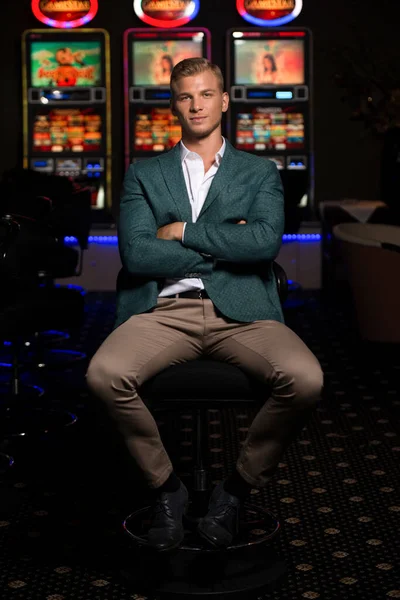 一个年轻貌美 衣冠楚楚的白人男子在赌场里玩耍的画像 — 图库照片
