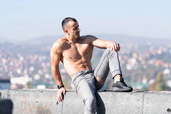 Handsome Young Man Sitting Strong Outdoors Flexing Muscles Old Rooftop — Stock Photo, Image