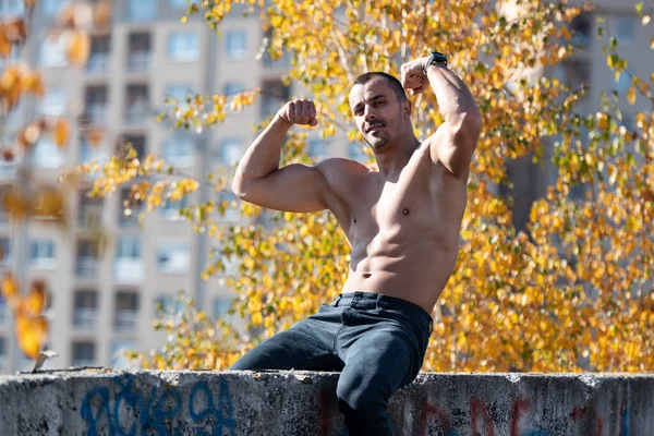 Hombre Joven Guapo Sentado Fuerte Aire Libre Músculos Flexionantes Azotea — Foto de Stock