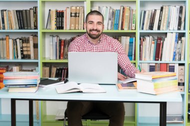 Sınav hazırlama ve dersler okul kütüphanesinde öğrenme - Laptop ve Gözat Internet üzerinde araştırma kütüphanede yapma öğrenci