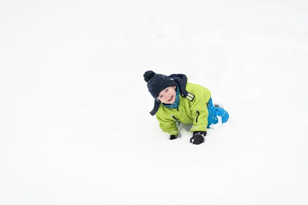 Boy Playing in Snow in the Woods While on Vacation