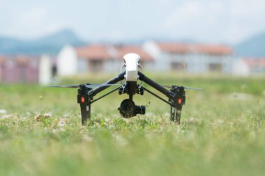 Drone resting on lush green grass, showcasing its sleek design clipart